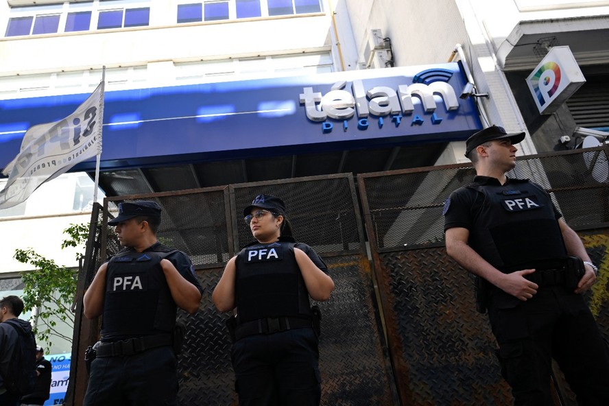 Membros da Polícia Federal Argentina vigiam a sede da agência de notícias estatal Telam em Buenos Aires