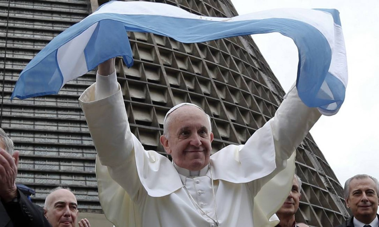 O Papa Francisco segura uma bandeira da Argentina em frente à catedral metropolitana no Rio de Janeiro, em julho de 2013. O primeiro pontífice jesuíta e latino-americano esteve no Brasil para o grande encontro católico Jornada Mundial da Juventude — Foto: STEFANO RELLANDINI