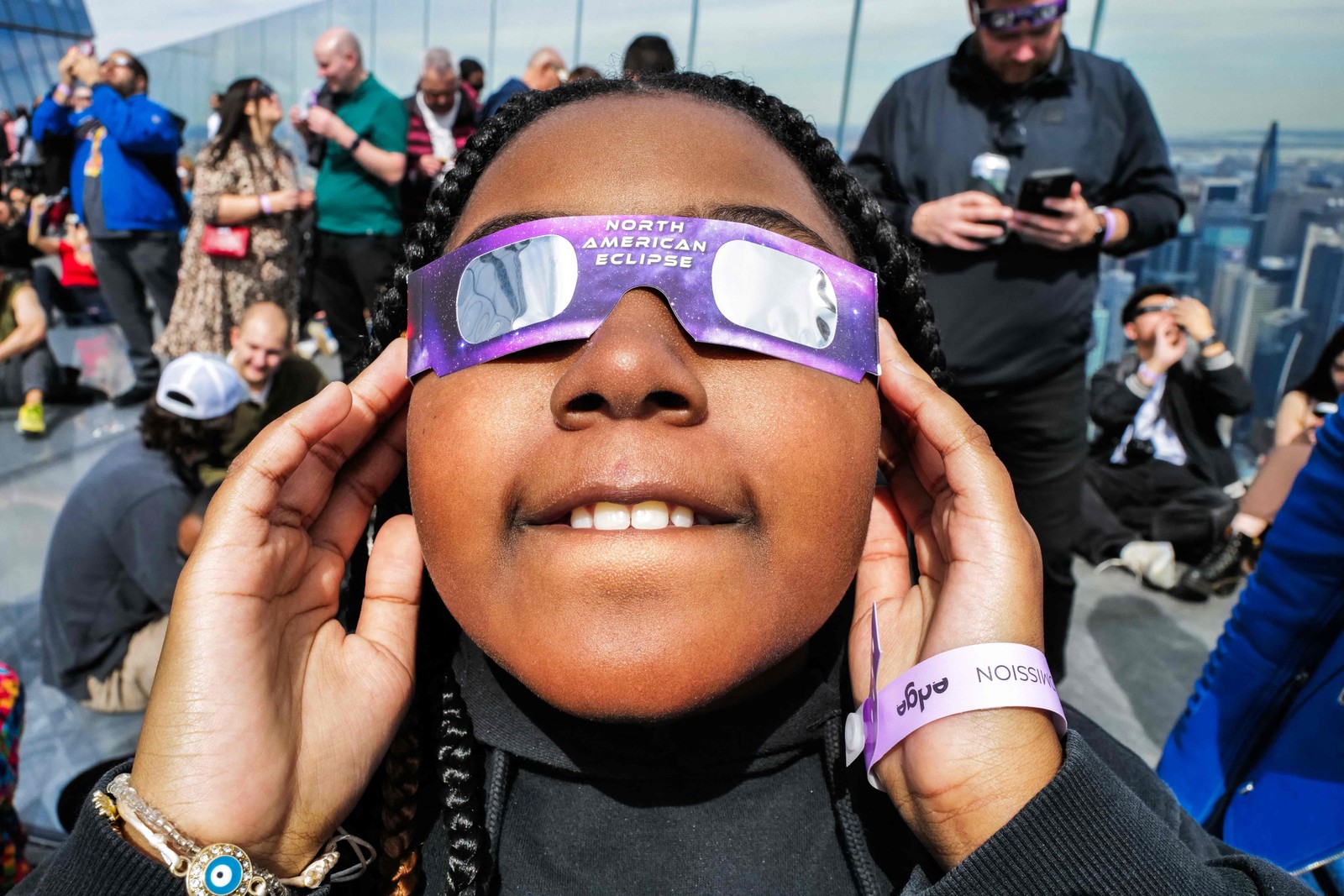 Uma Jovem olha para océuno deck deobservação'Edge in the Hudson Courtyard Edge'durante o eclipse o eclipse solar na cidade de nova York. - Foto: Charly Triballeau / AFP