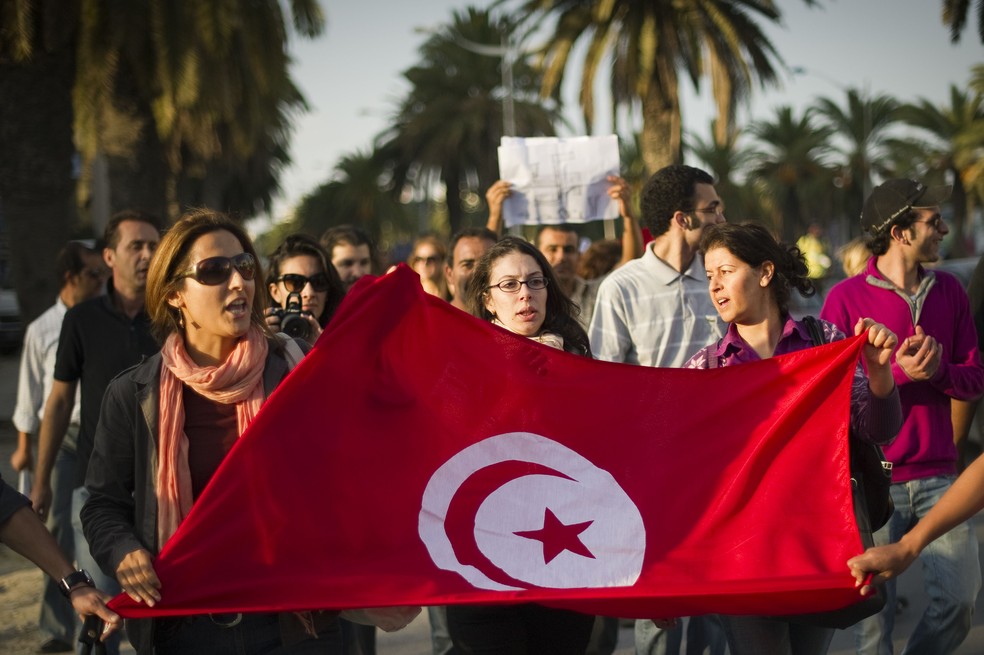 Manifestantes tunisianos fazem protesto em frente à sede da autoridade eleitoral do país — Foto: LIONEL BONAVENTURE/AFP