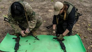 Dois participantes em uma sessão de treinamento praticam o carregamento de balas em um carregador — Foto: Brendan Hoffman / New York Times