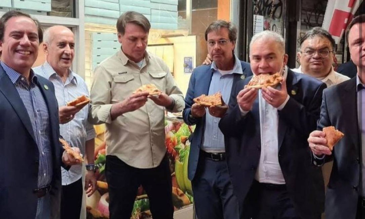 Bolsonaro come pizza na calçada em Nova York, com ministros, em setembro: sem estar vacinado, presidente não poderia entrar em restaurantes da cidade  — Foto: Reprodução