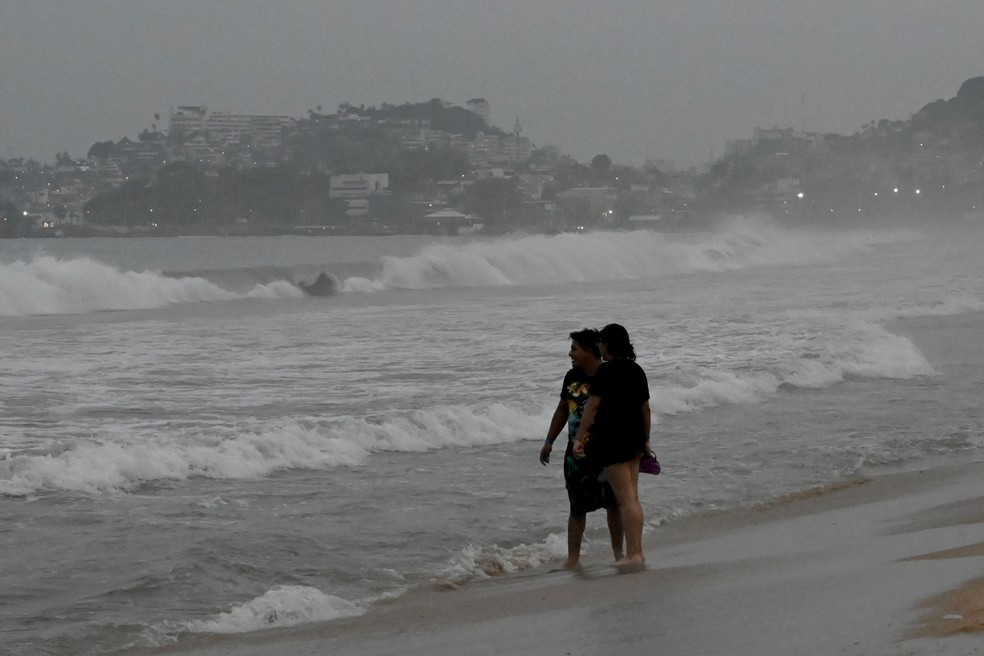 Banhistas na praia após o alerta de chegada do furacão Otis, em Acapulco, Estado de Guerrero, México — Foto: Francisco Robles / AFP