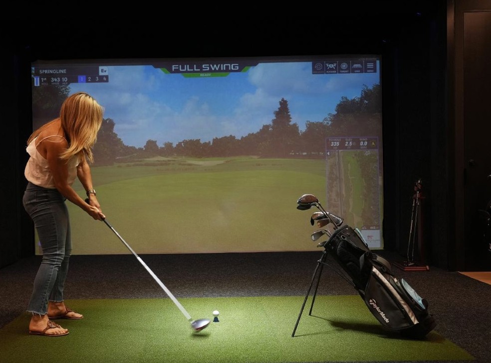 O simulador de golfe do Springline: a transformação de escritórios tradicionais em espaços de trabalho com comodidades semelhantes às de um hotel é designada por “hotelificação” — Foto: Jim Wilson/The New York Times