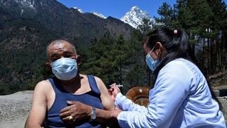Um profissional de saúde inocula um homem com a dose da vacina Covishield contra o Covid-19 em um posto de saúde perto de Lukla, no nordeste do Nepal — Foto: PRAKASH MATHEMA / AFP