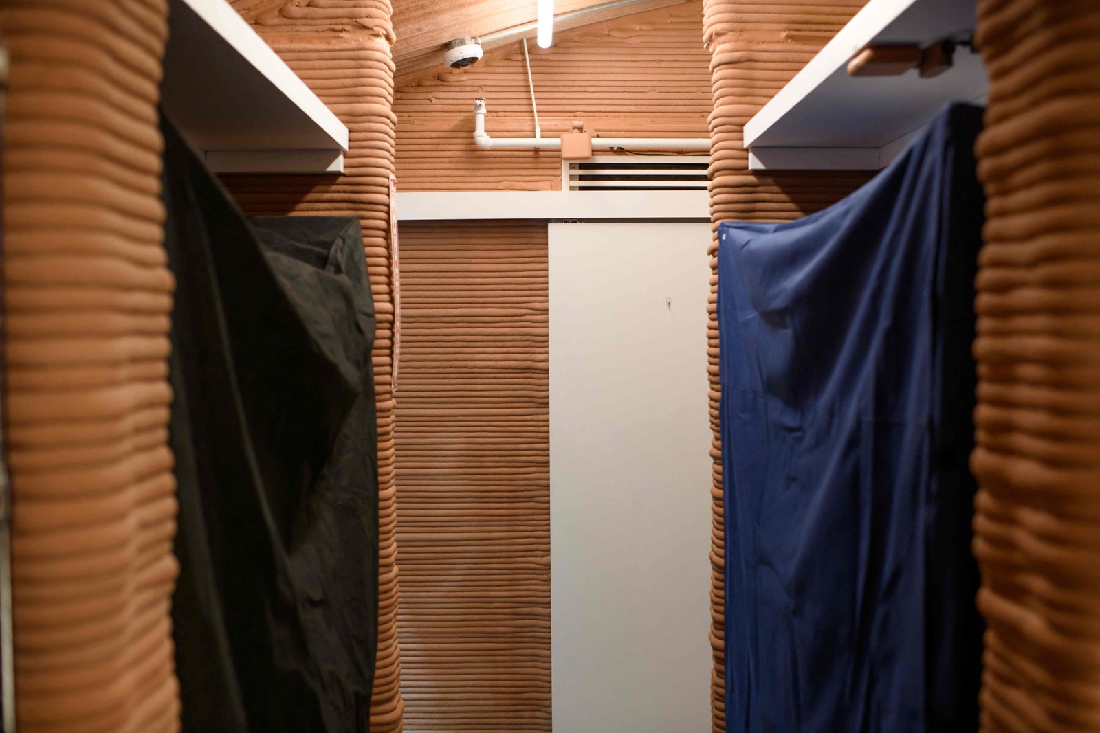 O “imóvel” tem quatro quartos, um por morador, zona para onde podem retirar-se caso necessitem de privacidade, uma sala com cozinha — Foto: Mark Felix / AFP