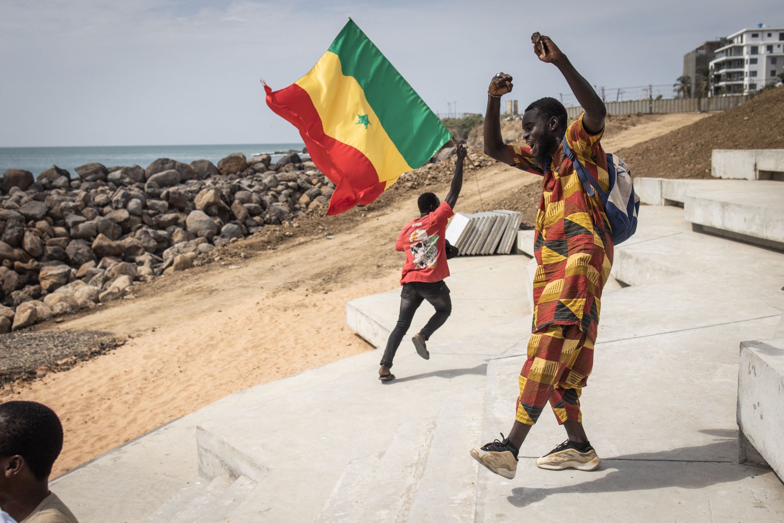 Senegalês comemora vitória por 3 a 1 da seleção em arena montada com telão em Dacar — Foto: John Wessels/AFP