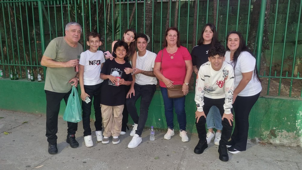Maurício Gimenez, 60 anos, abraçado ao neto, Leonardo, de 13 anos, que o apresentou a Kings League. Também há mais quatro netos, duas filhas e a esposa de Maurício. Todos foram assistir ao jogo — Foto: Arthur Falcão