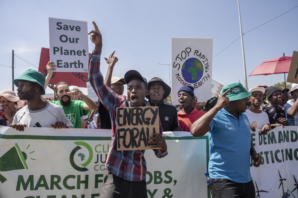 Grupo de ativistas ambientais se reúne para protestar contra a empresa estatal de energia Eskom, pela poluição do ar causada pelo alto uso de carvão em Soweto — Foto: Ihsaan Haffejee/Anadolu via AFP