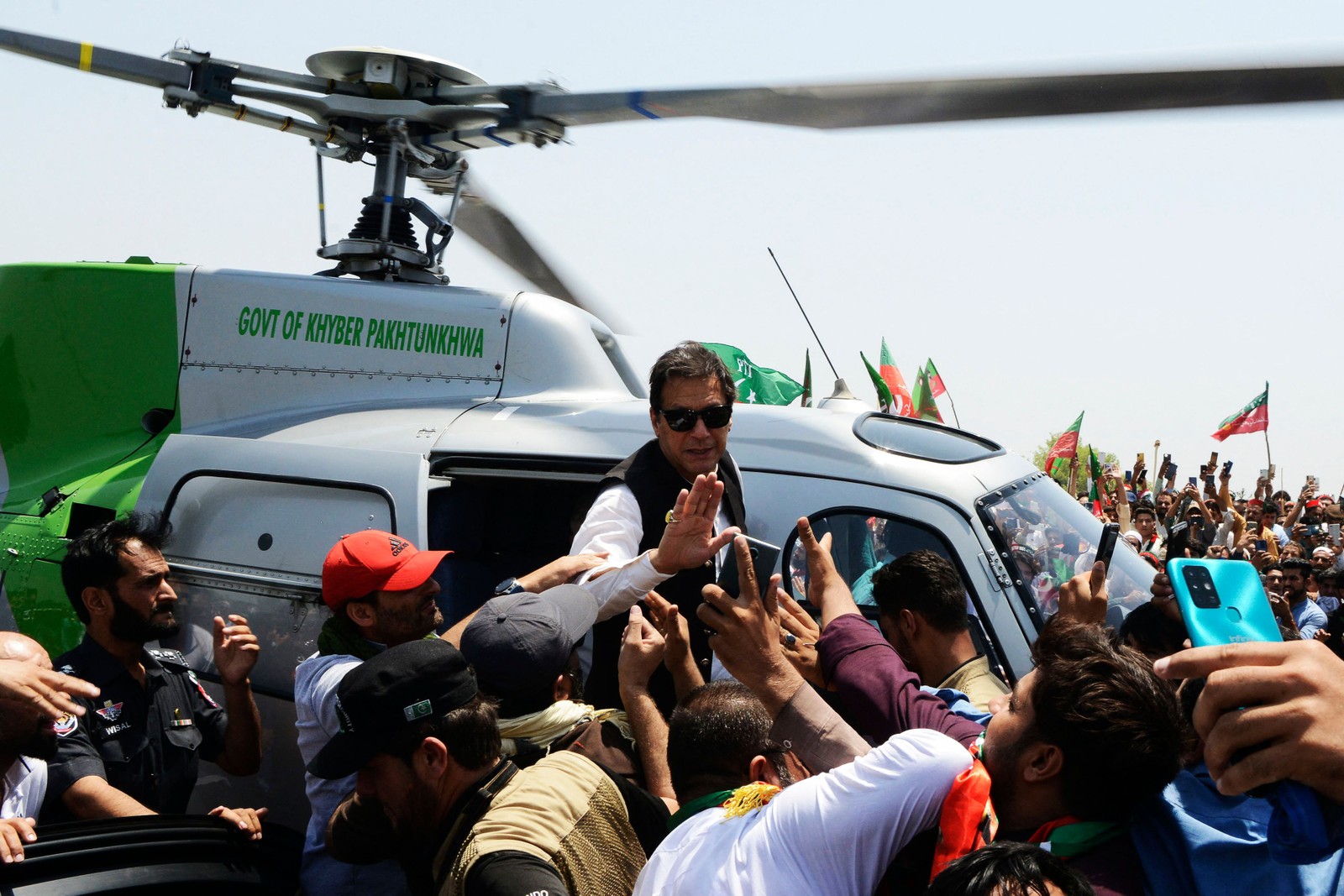 O primeiro-ministro deposto do Paquistão, Imran Khan, acena para os apoiadores ao chegar em um helicóptero para liderar uma manifestação de protesto em Swabai. Todas as estradas que levam à capital do Paquistão, Islamabad foram bloqueadas depois de convocação do primeiro-ministro deposto — Foto: ABDUL MAJEED / AFP