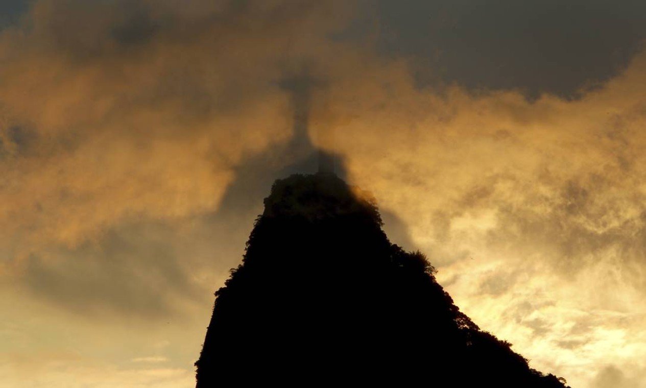 Silhueta do Cristo é vista através de nuvens que cobrem o cume da pedra do Corcovado Foto:  — Foto: Custódio Coimbra / Agência O Globo