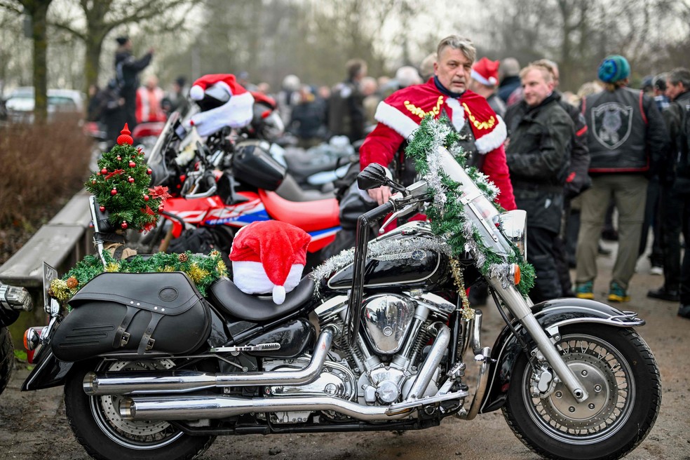 Piloto vestido de Papai Noel fica perto de sua motocicleta decorada durante uma reunião para motociclistas na véspera de Natal em Hagen, na Alemanha — Foto: AFP/ Ina Fassbender