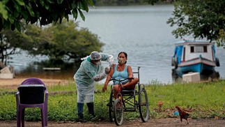 Profissional de saúde da Secretaria de Saúde Indígena do Ministério da Saúde administra uma segunda dose da vacina contra COVID-19 a uma mulher da aldeia Esperança do Rio Arapiun, no Baixo Amazonas, estado do Pará, próximo a Santarém — Foto: TARSO SARRAF / AFP