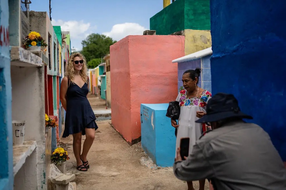 Um turista posando no cemitério de Pomuch — Foto: The New York Times