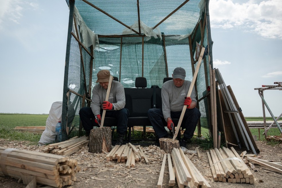 Voluntários atuam em desminagem em campo próximo ao front na Ucrânia — Foto: AFP