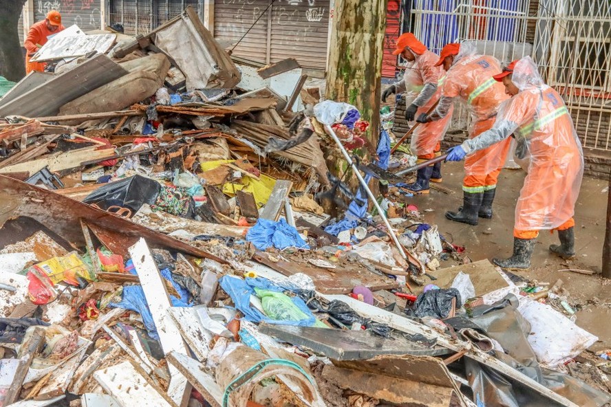 Ap&oacute;s fortes chuvas, funcion&aacute;rios do departamento municipal de limpeza urbana (DMLU), fazem a retirada de lixo acumulado nas ruas de Porto Alegre