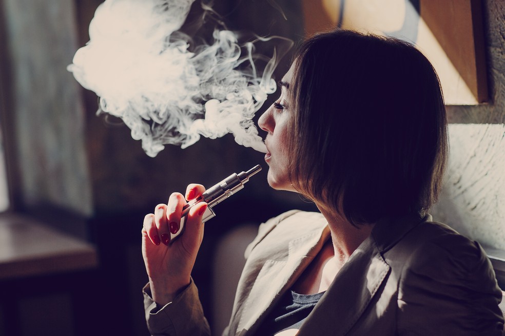 Mulher inala vapor produzido por cigarro eletr&ocirc;nico &mdash; Foto: Freepik