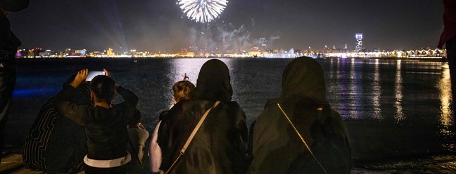 Mulheres olham para fogos de artifício explodindo no céu em Doha abertura do torneio de futebol da Copa do Mundo Qatar — Foto: FADEL SENNA/AFP