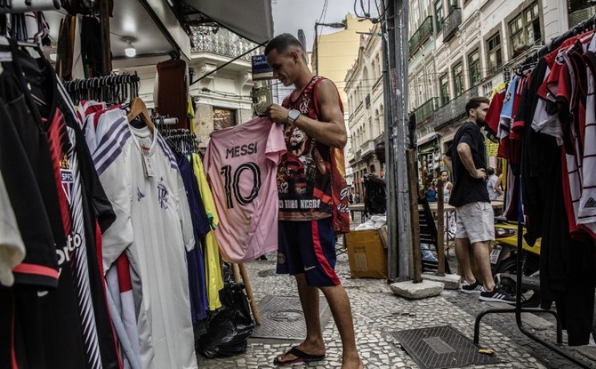 Consumidor com a camisa 10, de Lionel Messi, na cor rosa característica do Inter Miami, em uma loja no Rio de Janeiro