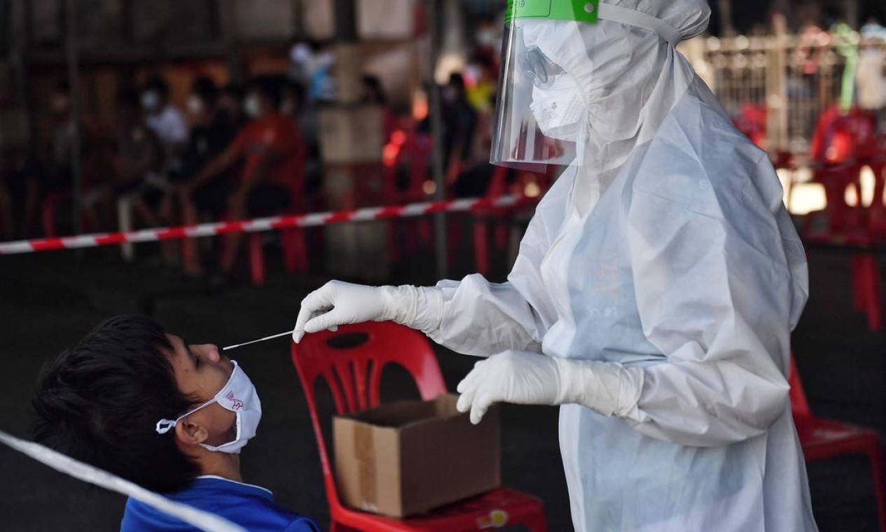 Equipe médica coleta um cotonete de nariz de um trabalhador migrante de Mianmar, em uma clínica móvel de testes de coronavírus, em Pathum Thani, ao norte de Bangkok — Foto: LILLIAN SUWANRUMPHA / AFP