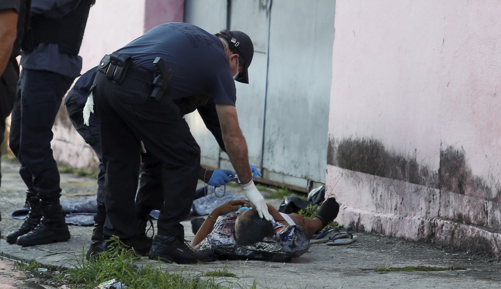 Policiais fazem perícia em corpo de vítima de operação policial na Vila da Penha, Zona Norte do Rio — Foto: Fabiano Rocha / Agência O Globo