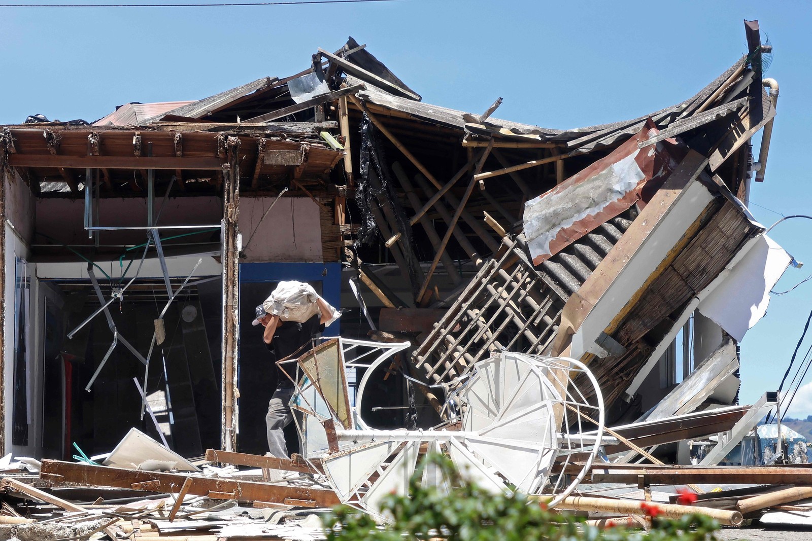 Um homem carrega uma bolsa saindo de uma construção desabada após um terremoto em Manizales, Colômbia, em 10 de agosto de 2026. — Foto: Giovanny Galvez / AFP