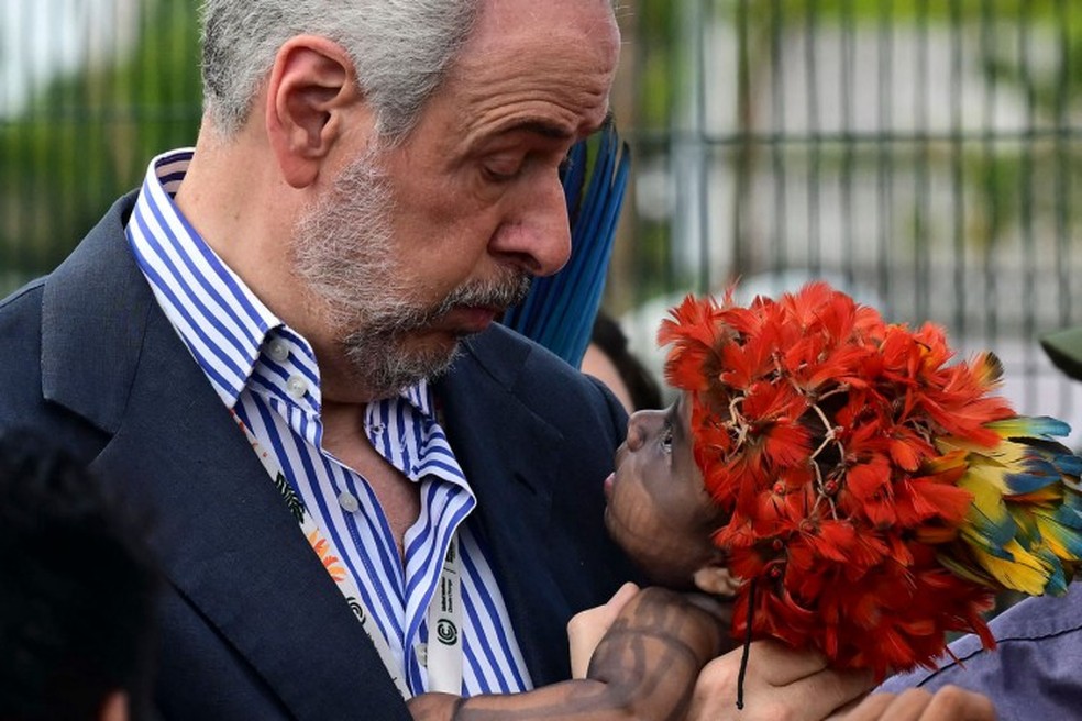 COP30 President Andre Correa de Lago holds a Munduruku indigenous child during a protest at the entrance of the event. — Photo: Pablo PORCIUNCULA / AFP