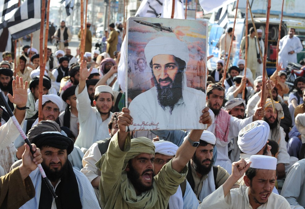 Manifestante levanta cartaz com o rosto do líder da rede al-Qaeda, Osama bin Laden, no Paquistão — Foto: BANARAS KHAN/AFP