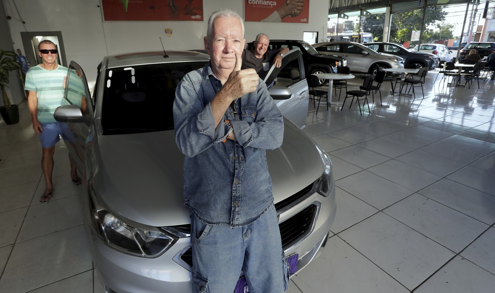 O servidor público Sérgio Machado, de 66 anos, no centro da foto, aproveitou preços mais baixos na Intendente Magalhães para levar um Cobalt 2017 — Foto: Marcelo Theobald