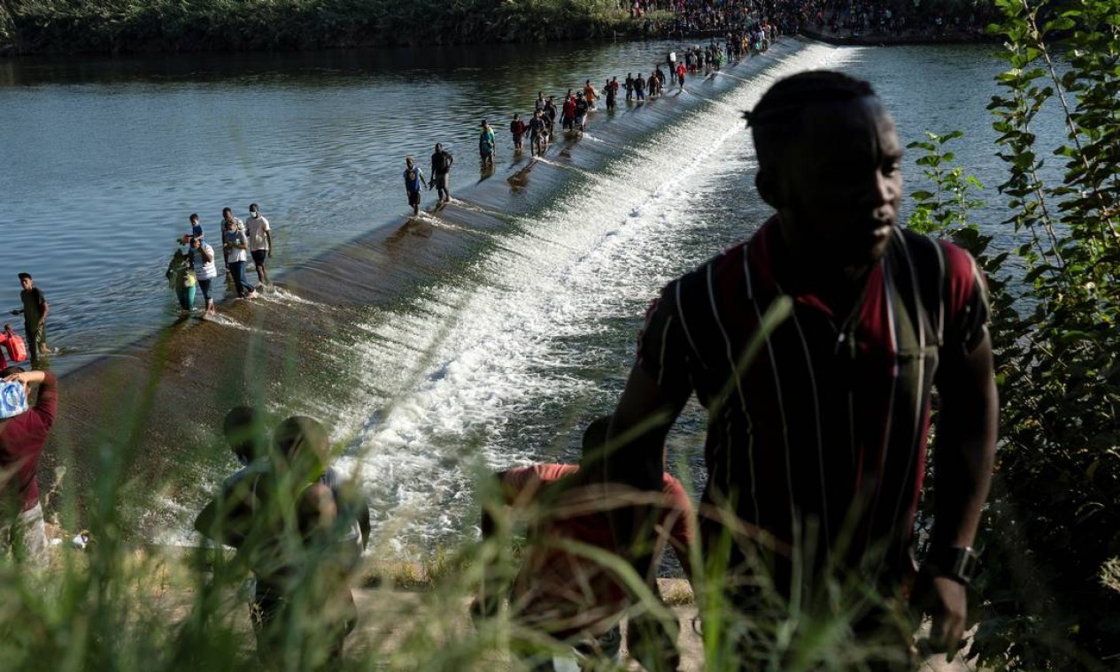 Imigrantes que buscam asilo nos EUA caminham no Rio Grande perto da Ponte Internacional entre o México e os EUA enquanto esperam para ser processados em Ciudad Acuña, no México.  — Foto: GO NAKAMURA / REUTERS - 16/09/2021