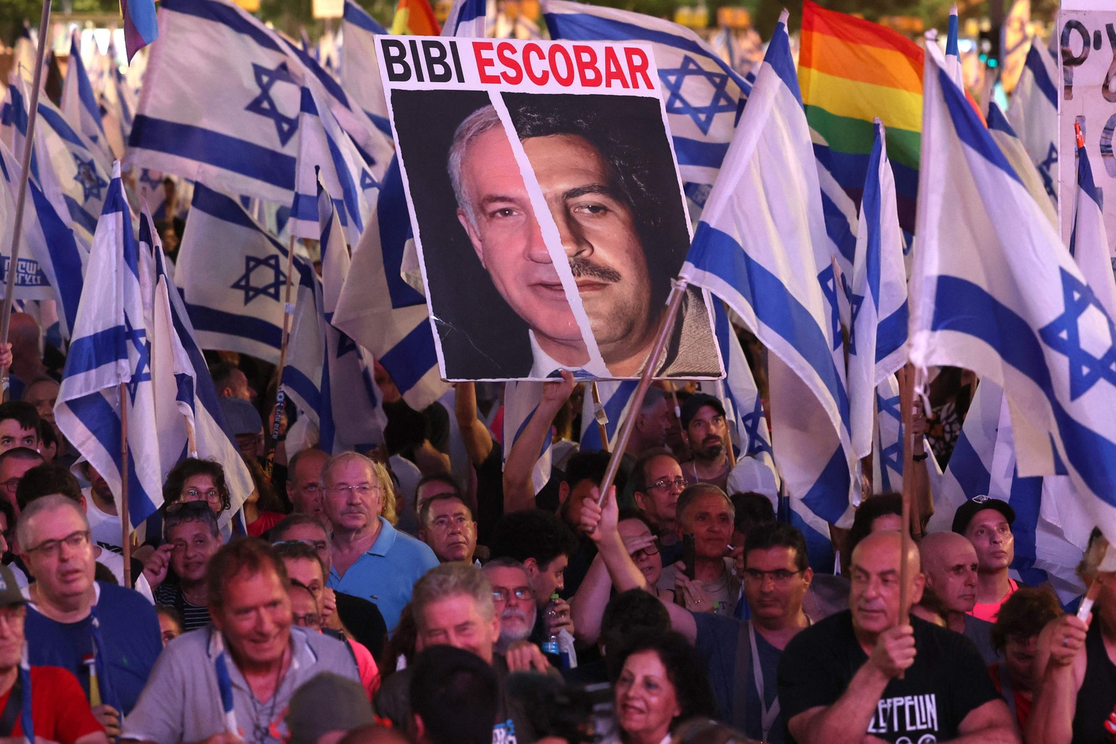 Manifestantes levantam bandeiras e cartazes durante uma manifestação contra o plano de revisão judicial do governo israelense em Tel Aviv — Foto: Jack Guez/AFP