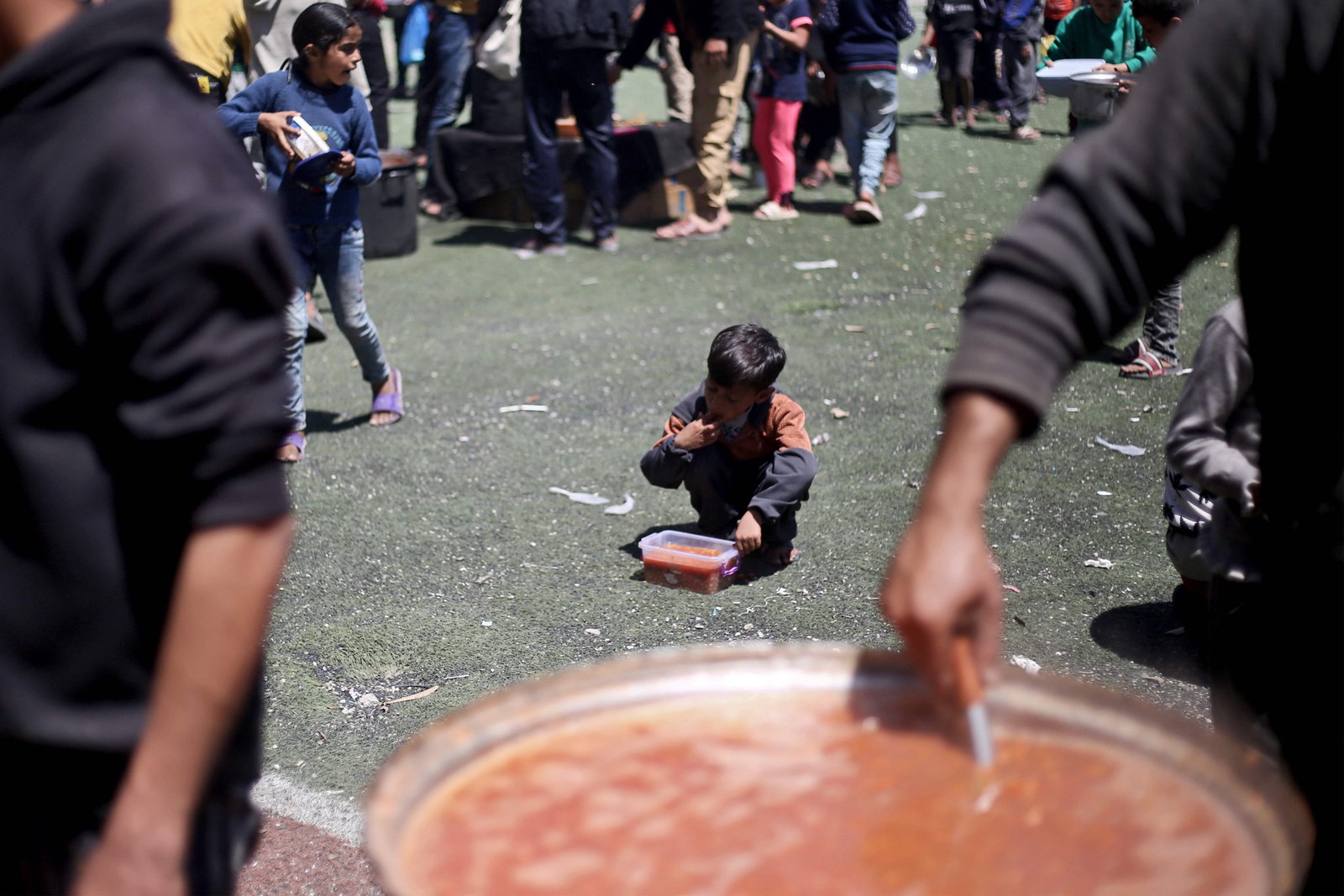 Criança Palestina Come Refeição emponto de Distriblução Gratuitade aliments no Campo de Revugiados de Nuseirat, no Centro da Faixa de Gaza -foto: Eyad Baba/AFP