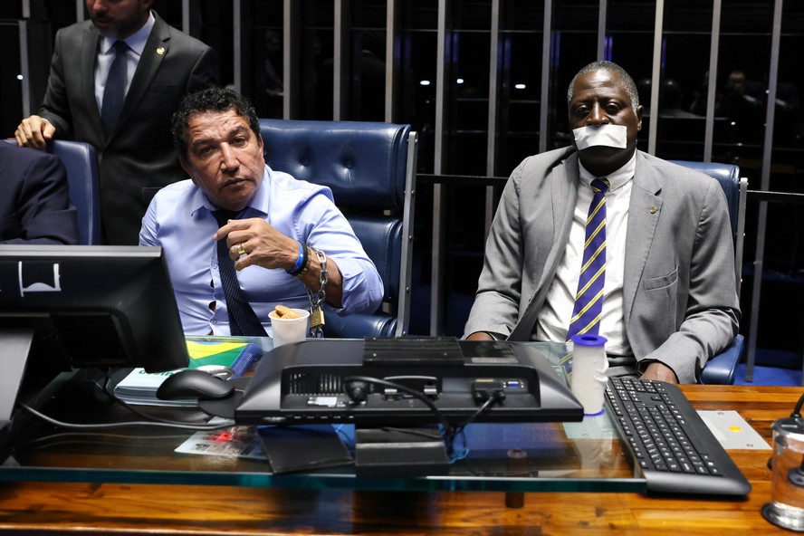 O senador Magno Malta e o deputado Hélio Lopes, do PL, acorrentados na mesa do plnário do Senado