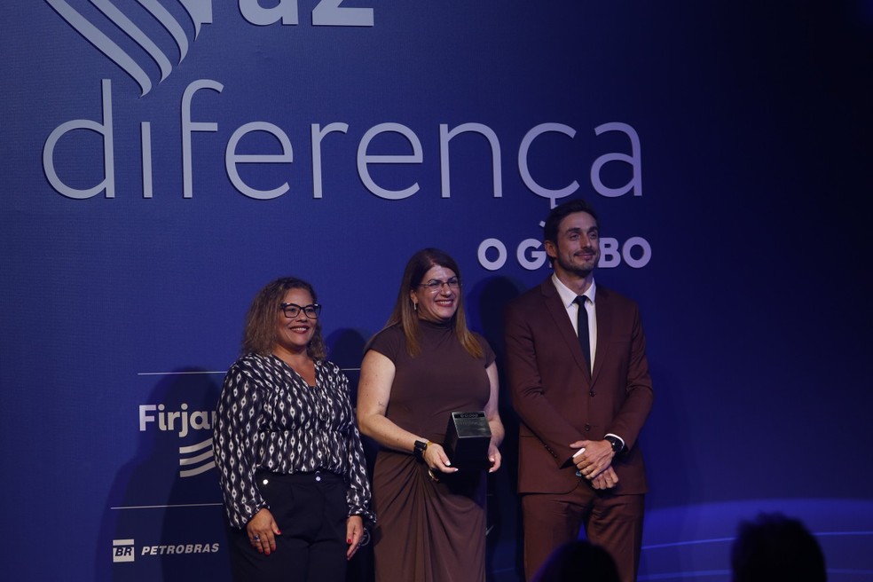A professora Débora Garofalo recebe o Prêmio Faz Diferença 2025 na categoria Educação das mãos de Flávia Barbosa, editora executiva do GLOBO, e Thiago Bronzatto, diretor da sucursal de Brasília do jornal — Foto: Alexandre Cassiano
