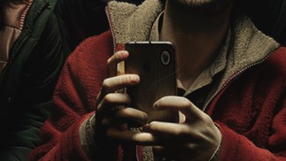 No cinema. A figura que segura o celular tem as mãos deformadas — Foto: Imagem gerada por IA/Midjourney