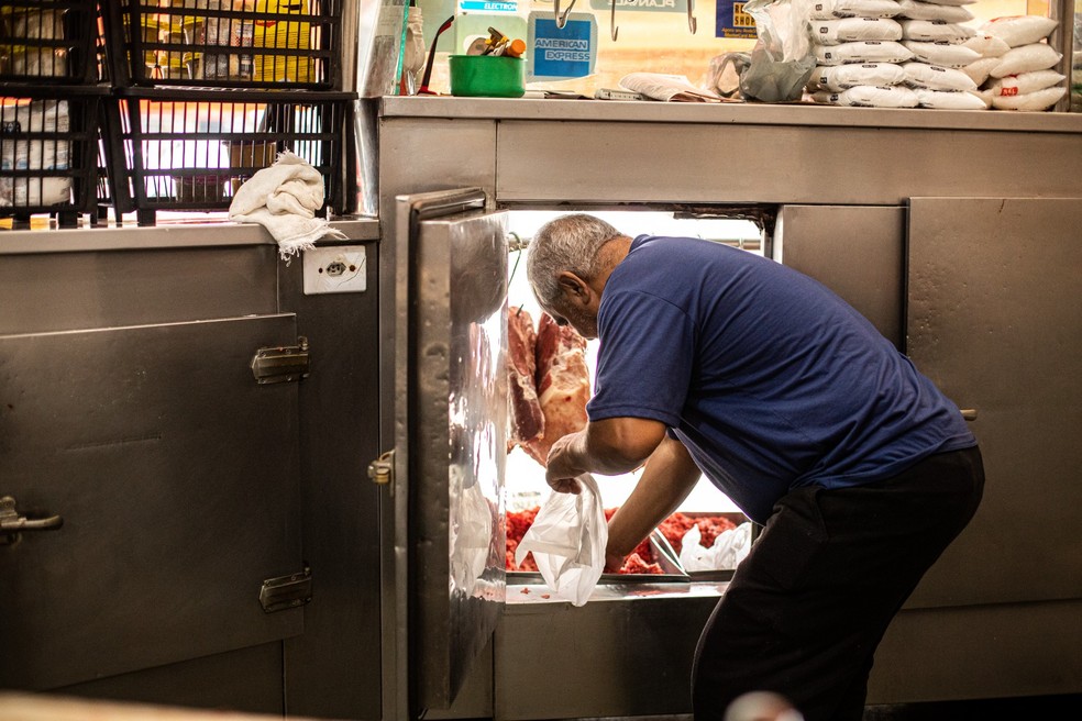 Para não perder mercadoria, açougue em Tauá, na Ilha do Governador, comprou sacos de gelo para manter produtos refrigerados — Foto: Hermes de Paula/Agência O Globo