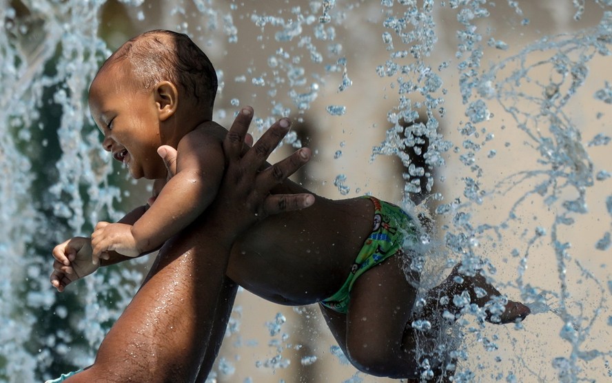 O bebê Daniel, de 10 meses, se refresca no Parque Madureira em dia de forte calor no Rio