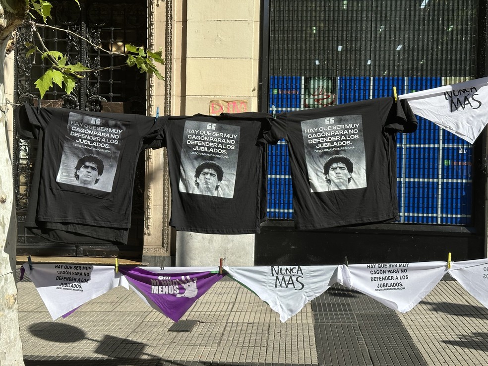 Camisas vendidas durante protesto, com estampa de Maradona e uma famosa frase do jogador:'É preciso ser muito cagão para não defender os aposentados' — Foto: Janaína Figueiredo