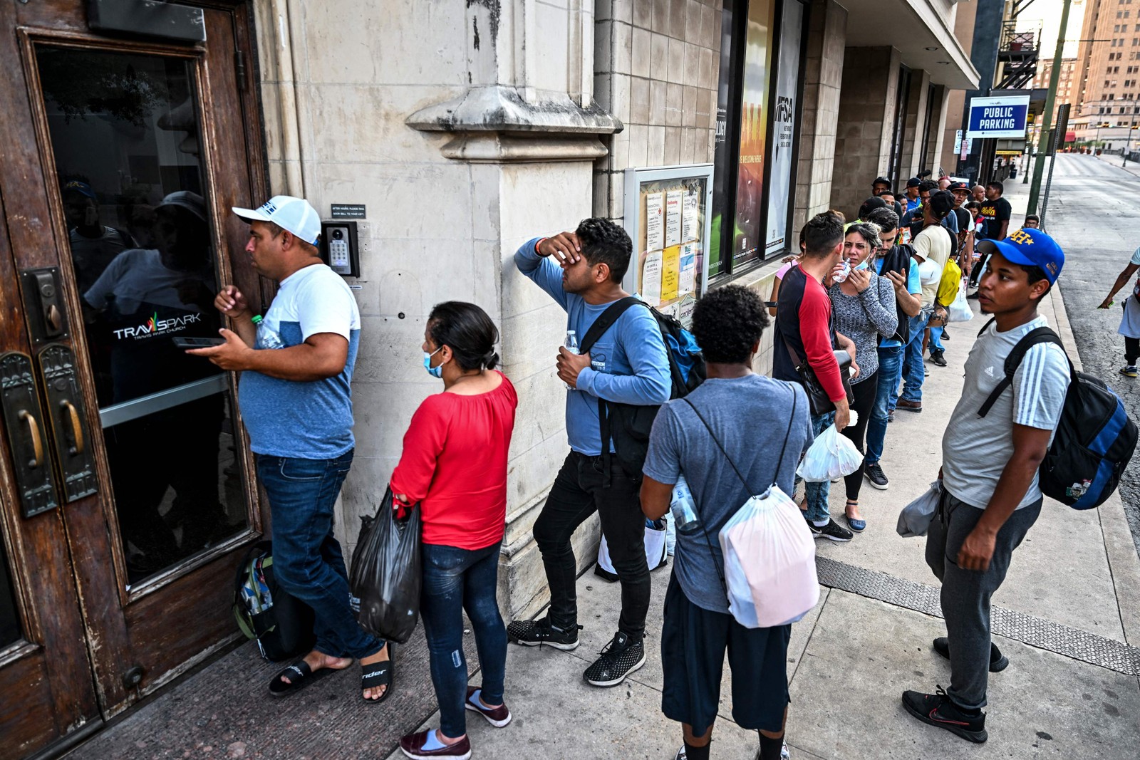 Dezenas de migrantes esperam na fila do lado de fora de um abrigo em San Antonio, a maioria deles jovens, mas também algumas mulheres e crianças, esperando por uma refeição quente e um teto sobre suas cabeças — Foto: CHANDAN KHANNA / AFP