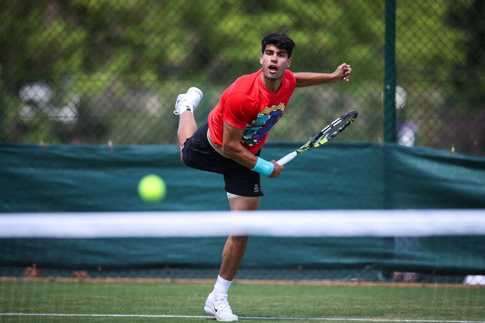 Representante da nova geração do tênis, Carlos Alcaraz treina para Wimbledon 2025 — Foto: HENRY NICHOLLS / AFP