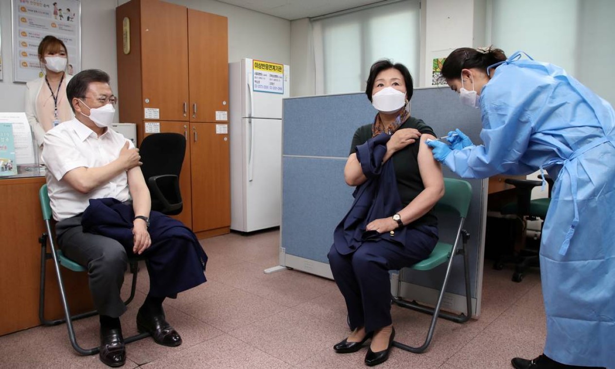 O presidente sul-coreano Moon Jae-in observa enquanto a primeira-dama Kim Jung-sook recebe uma vacina contra o coronavírus, na capital Seul, Coreia do Sul — Foto: YONHAP NEWS AGENCY / REUTERS