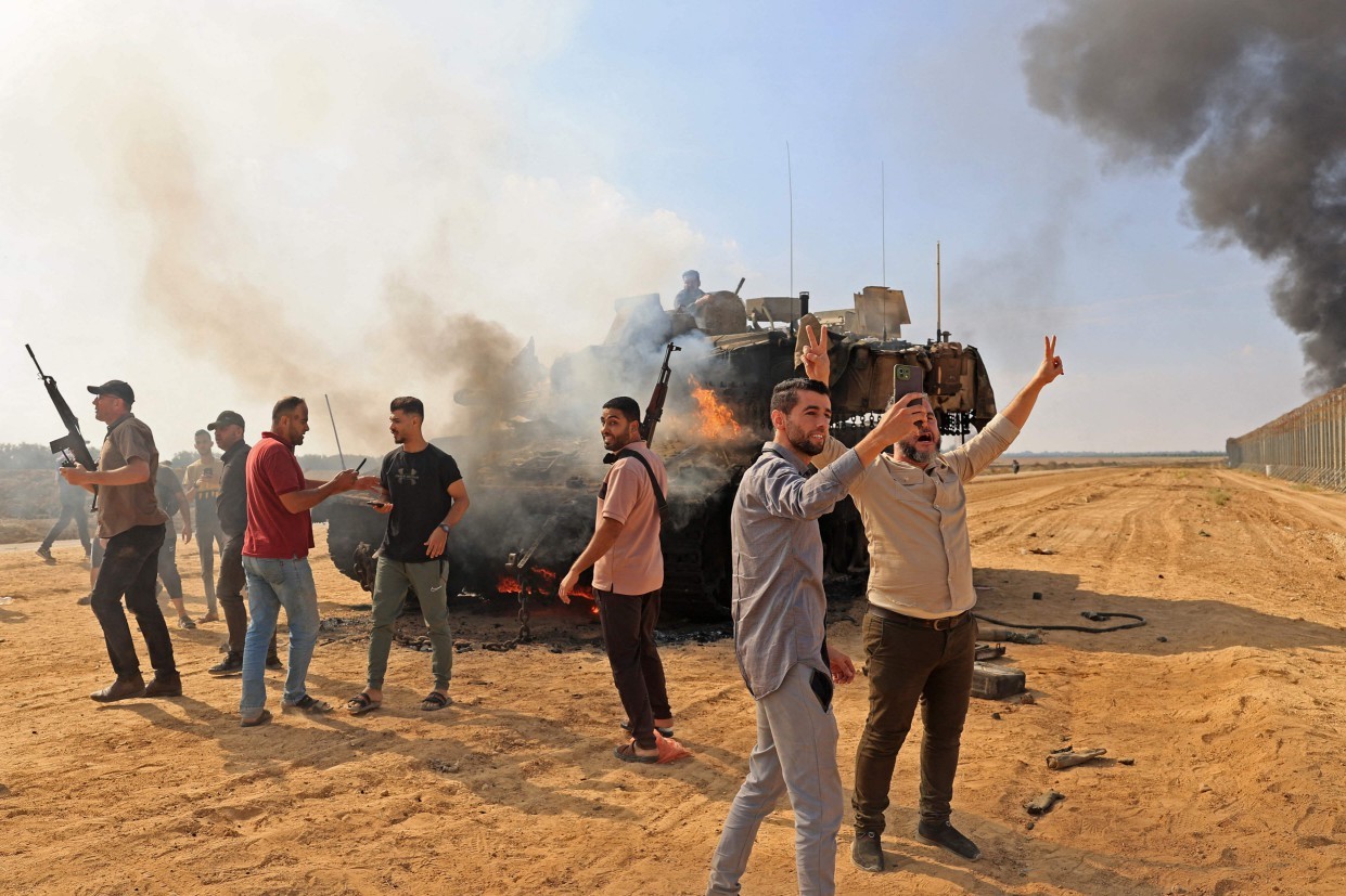 Palestinos assumem o controle de um tanque israelense depois de cruzar a cerca de fronteira com Israel de Khan Yunis, no sul da Faixa de Gaza – SAID KHATIB / AFP 