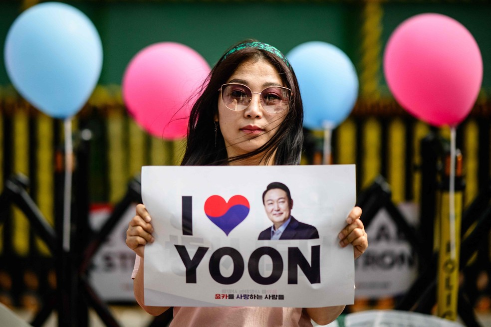 Lee Ju-hean, refugiada da Coreia do norte e apoiadora do ex-presidente Yoon Suk-yeol, em ato do lado de fora de tribunal de Seul onde ele prestou depoimento — Foto: ANTHONY WALLACE / AFP