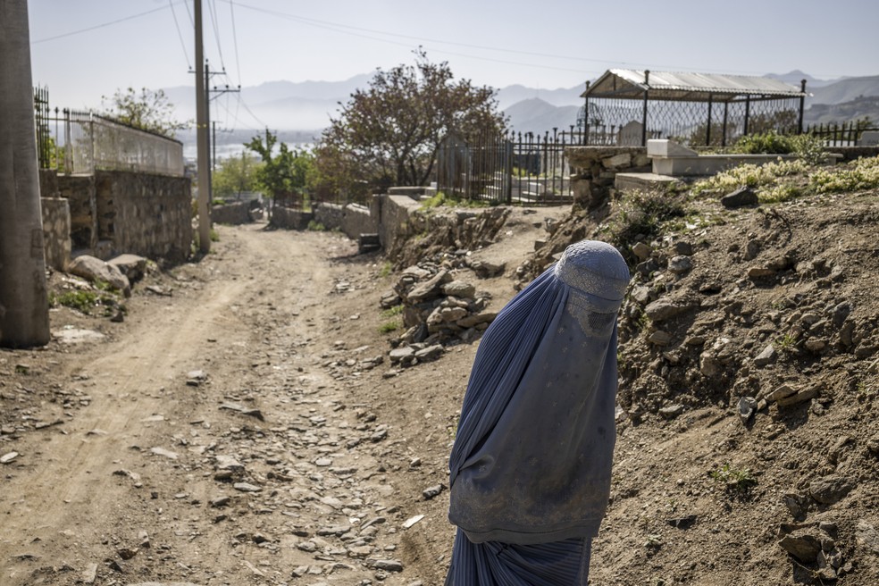 A woman walks on a road in Kabul, Afghanistan, on April 20, 2023, her body completely covered; The oppressive Taliban regime now even bans women's voices in public spaces - Photograph: Jim Hoelbrook/The New York Times