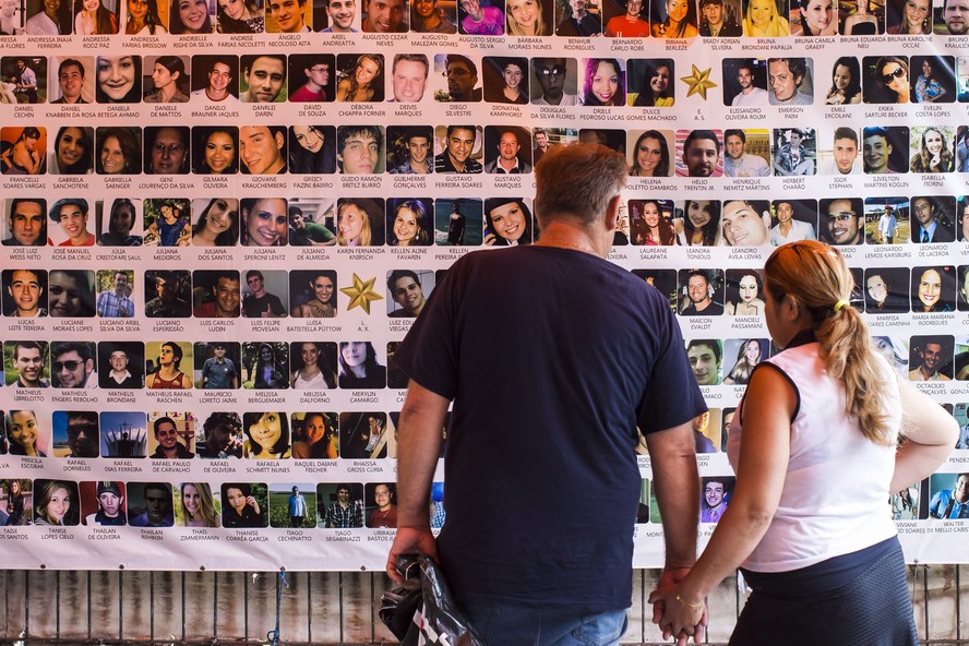Casal observa painel em homenagem às 242 vítimas do incêndio na Boate Kiss