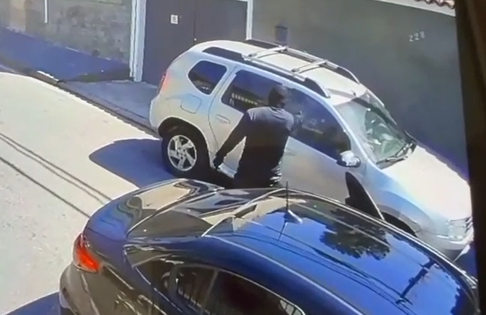 Vítima havia acabado de entrar no carro quando foi surpreendida por um homem encapuzado — Foto: Reprodução