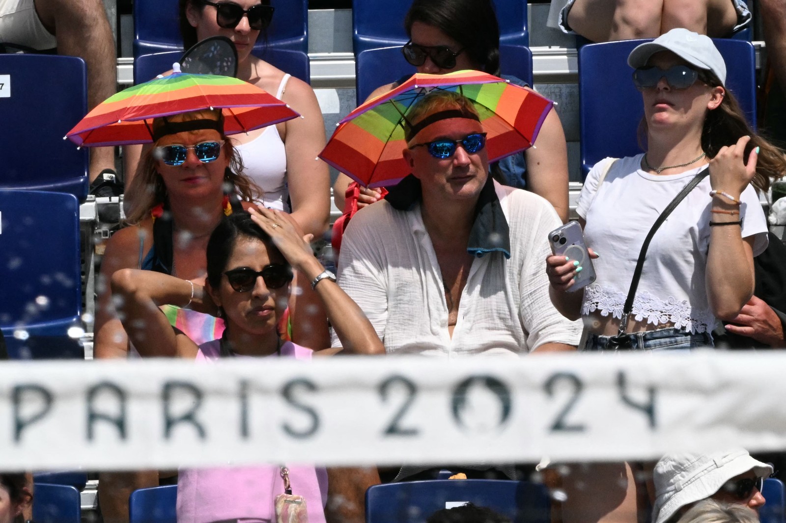 Supporters use umbrellas to protect themselves from the intense heat in Paris — Photo: Kirill KUDRYAVTSEV / AFP