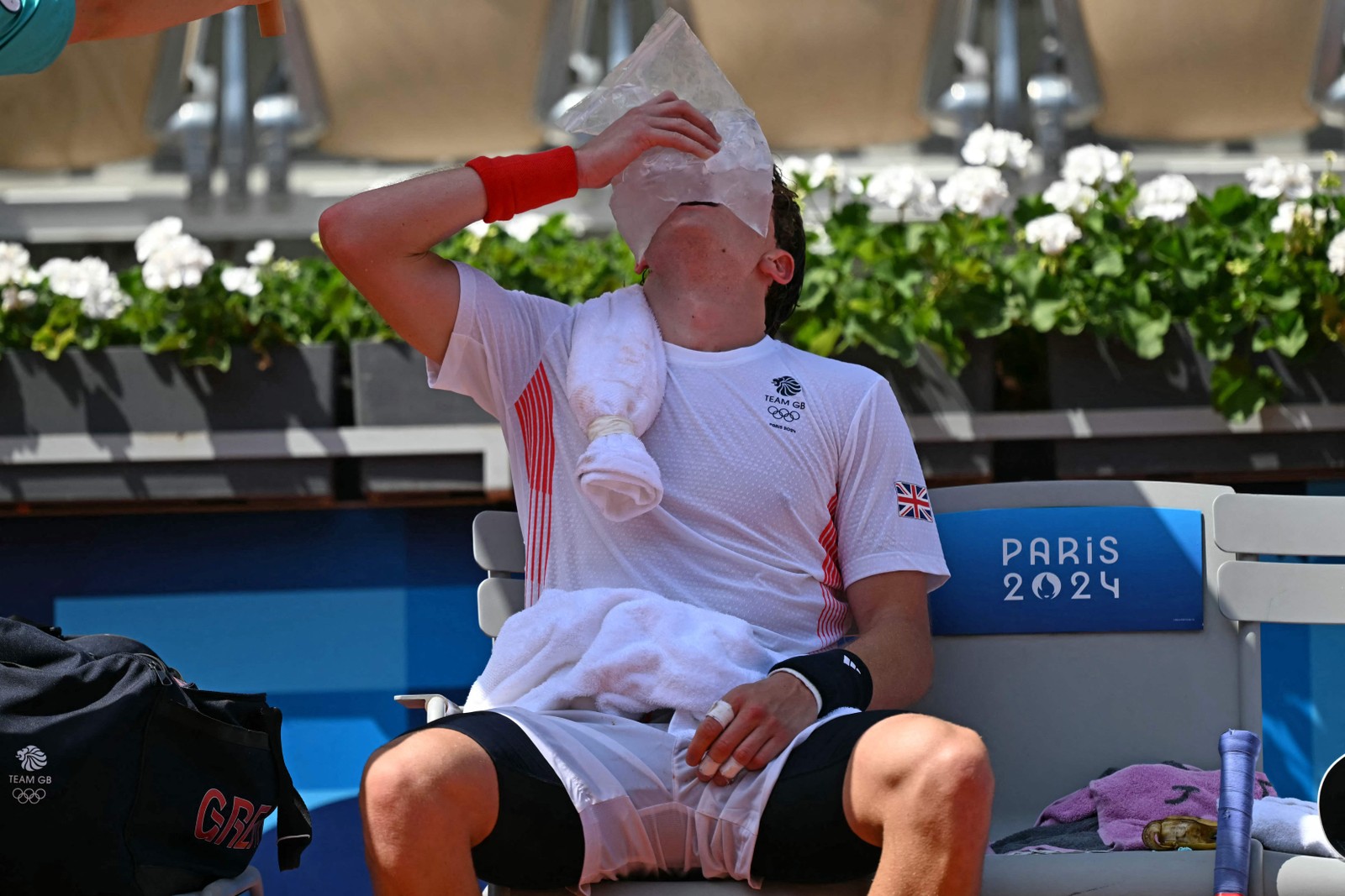British tennis player Jack Draper cools down with an ice pack during a break during his match against American Taylor Fritz — Photo: Martin Bernetti / AFP