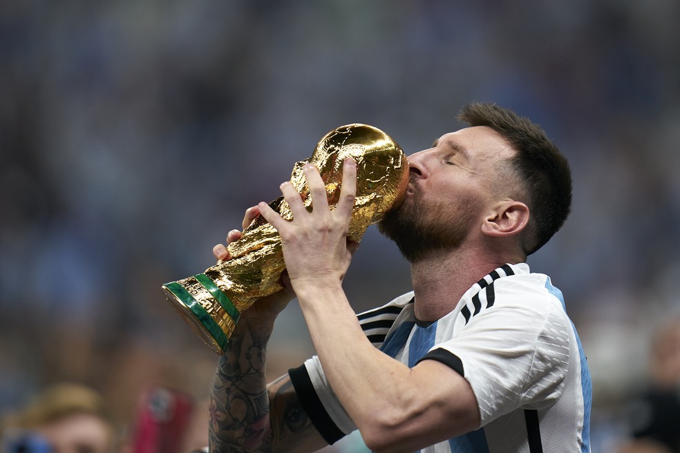 Lionel Messi of Argentina kisses the FIFA World Cup Qatar 2022 Winner's Trophy after the FIFA World Cup Qatar 2022 Final match between Argentina and France at Lusail Stadium on December 18, 2022 in Lusail City, Qatar — Foto: Quality Sport Images / Getty Images