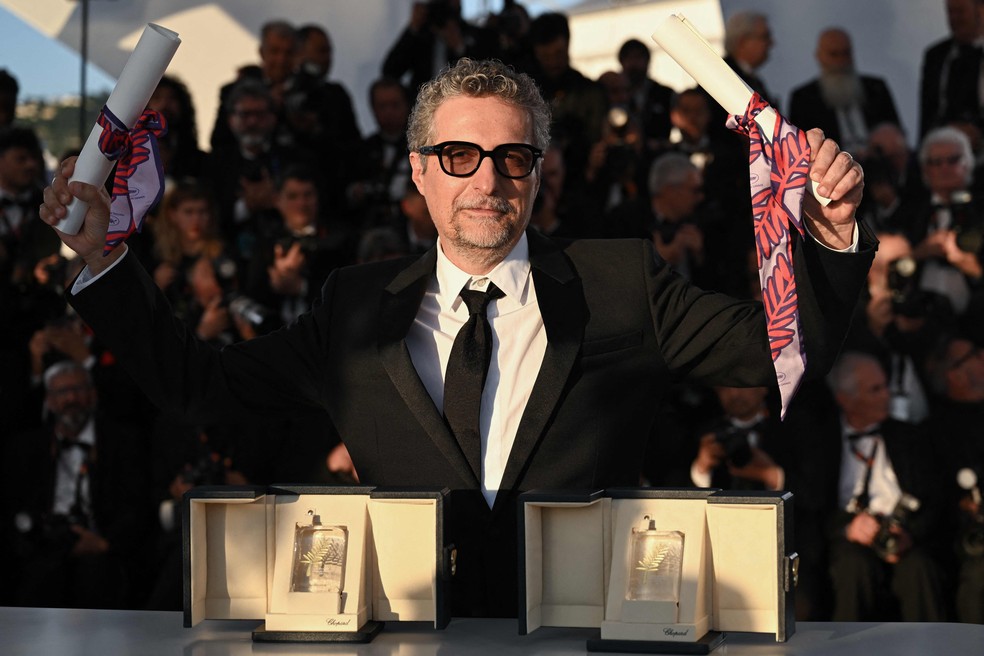 Kleber Mendonça Filho com prêmios de "O agente secreto" no Festival de Cannes — Foto: Bertrand GUAY / AFP